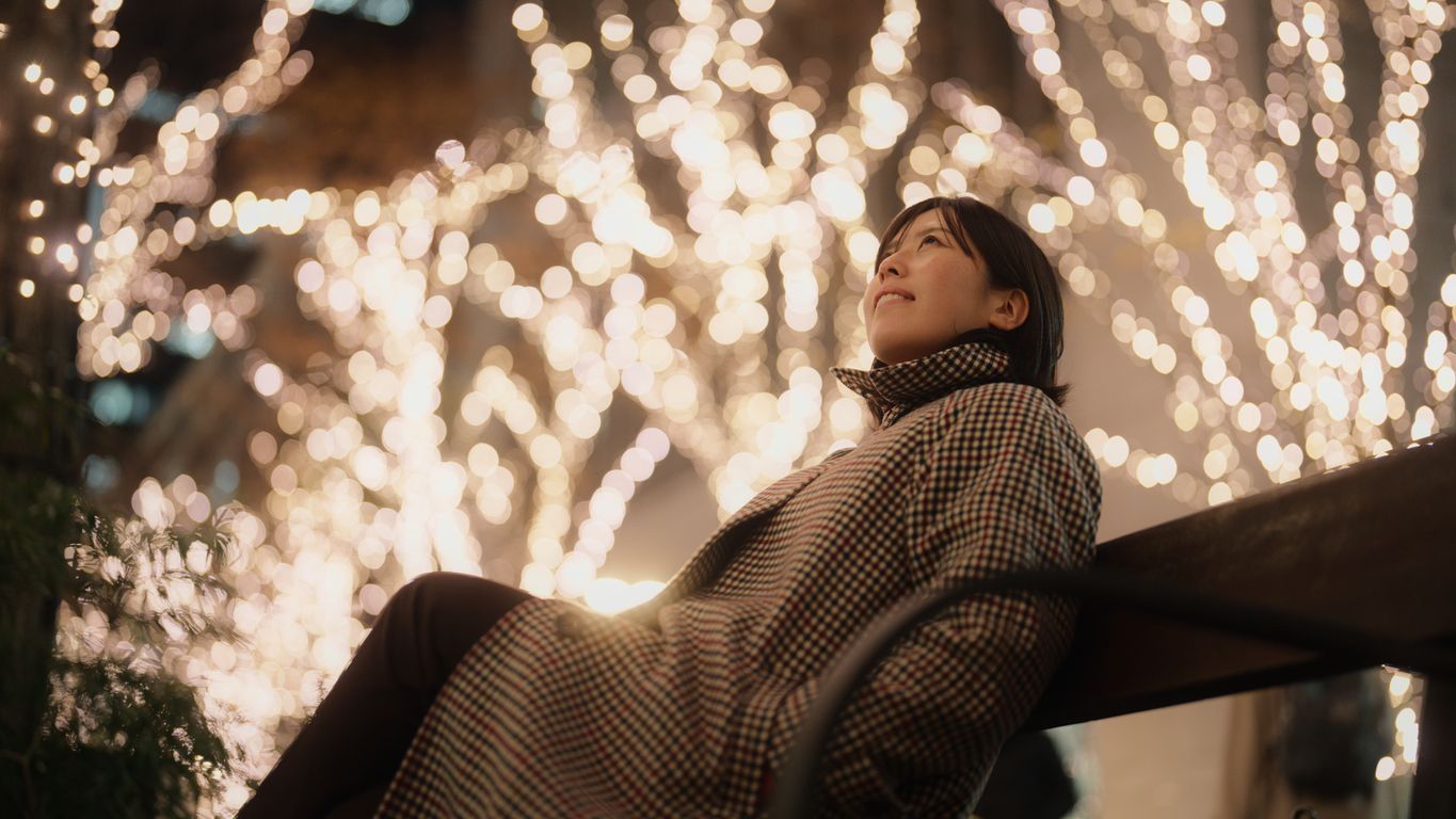 Person walking under a canopy of Christmas lights