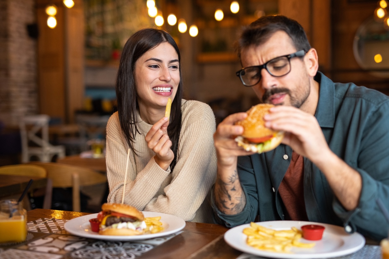 Couple enjoying burgers and fries at a restaurant