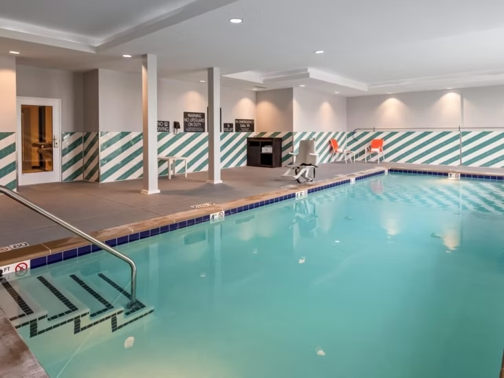 Heated indoor saltwater pool at Holiday Inn Clarksville Northeast with modern seating area and bright contemporary design.